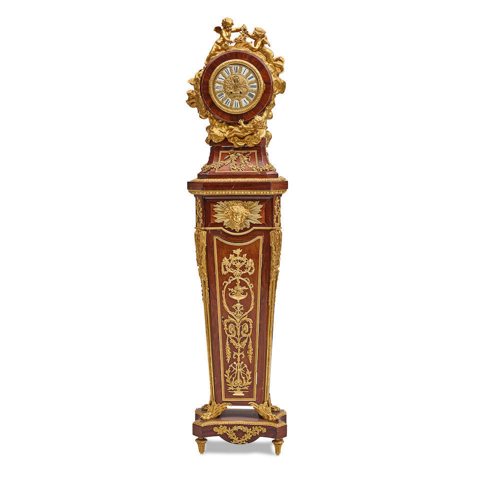 A LOUIS XVI STYLE GILT BRONZE MOUNTED TULIPWOOD, KINGWOOD, AND AMARANTH PEDESTAL CLOCKAfter the ...