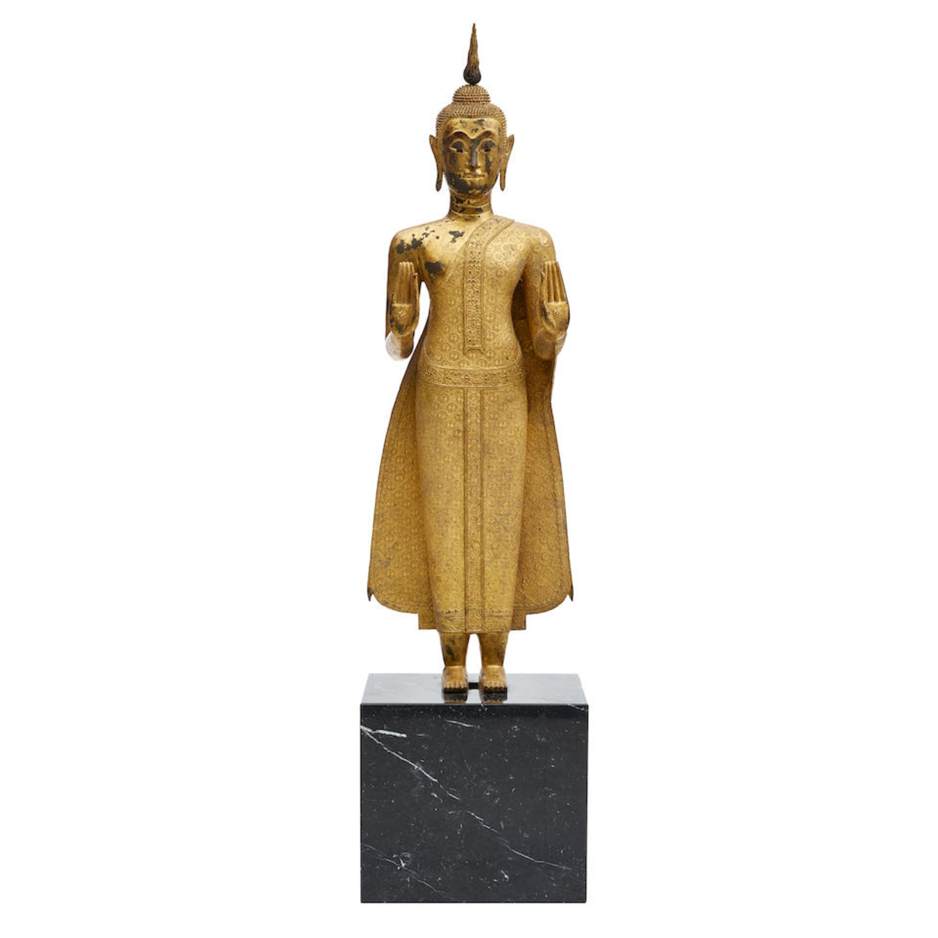 A THAI GILT METAL FIGURE OF A STANDING BUDDHA