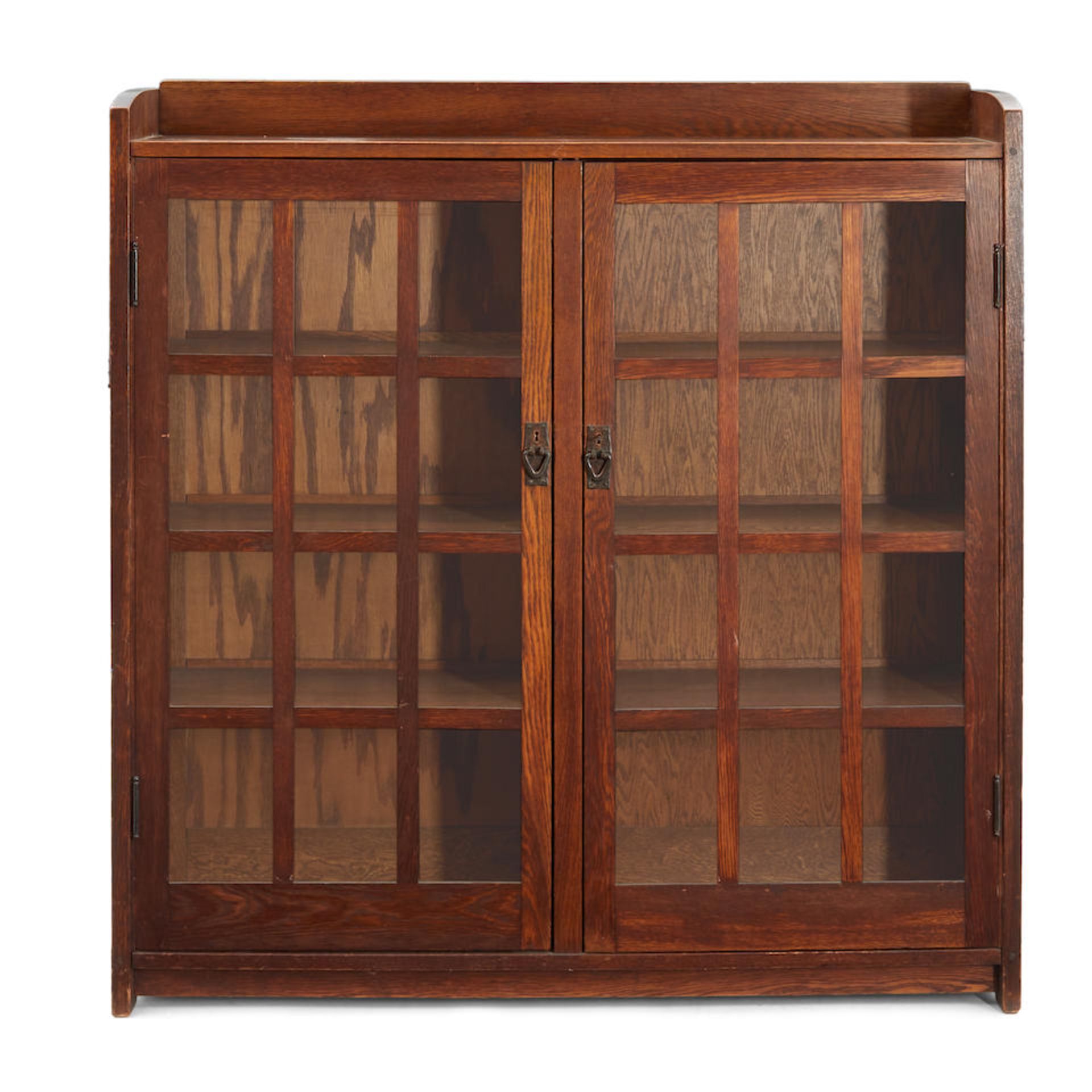 GUSTAV STICKLEY (1858-1942) DOUBLE-DOOR BOOKCASE NO. 718 Eastwood, New York, c. 1905, oak, coppe...