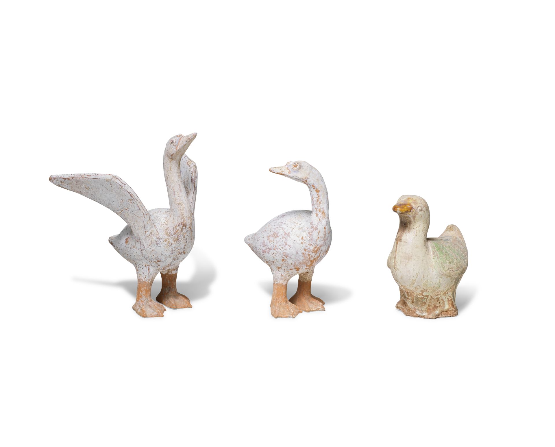 A PAIR OF PAINTED POTTERY MODELS OF GEESE AND A GREEN AND OCHRE-GLAZED POTTERY MODEL OF A DUCK T...