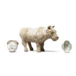 A POTTERY MODEL OF AN OX, A PAINTED POTTERY HEAD AND A GREEN-GLAZED EAR CUP The ox, Wei Dynasty;...