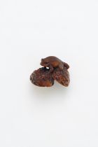 AN INLAID WOOD FROG AND WALNUT THEME NETSUKE Meiji Period, 19th Century