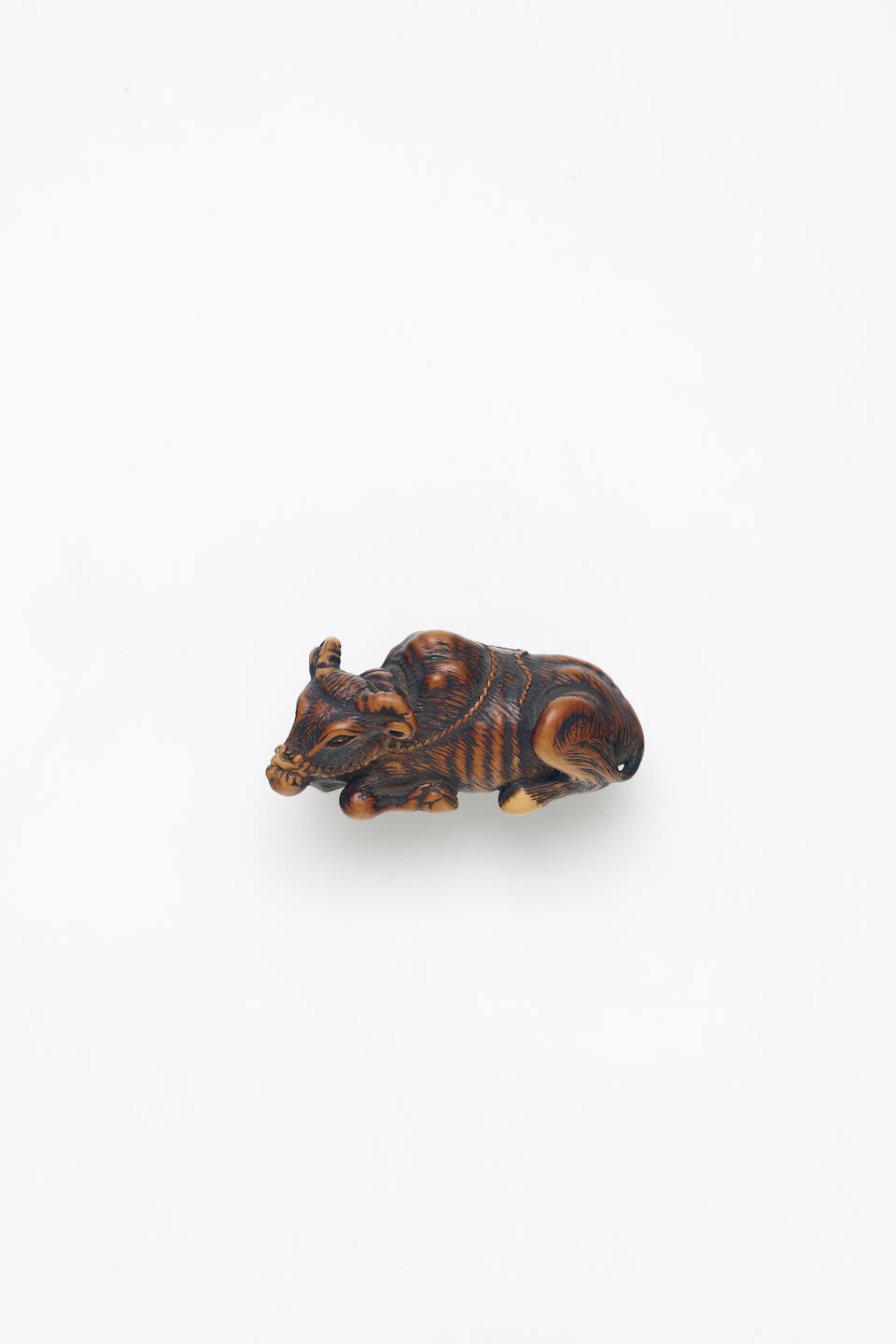 A WOOD NETSUKE OF A RECUMBENT BUFFALO Edo Period, circa mid 19th Century