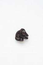 A WOOD NETSUKE OF A RECUMBENT TIGER Edo Period, 19th Century