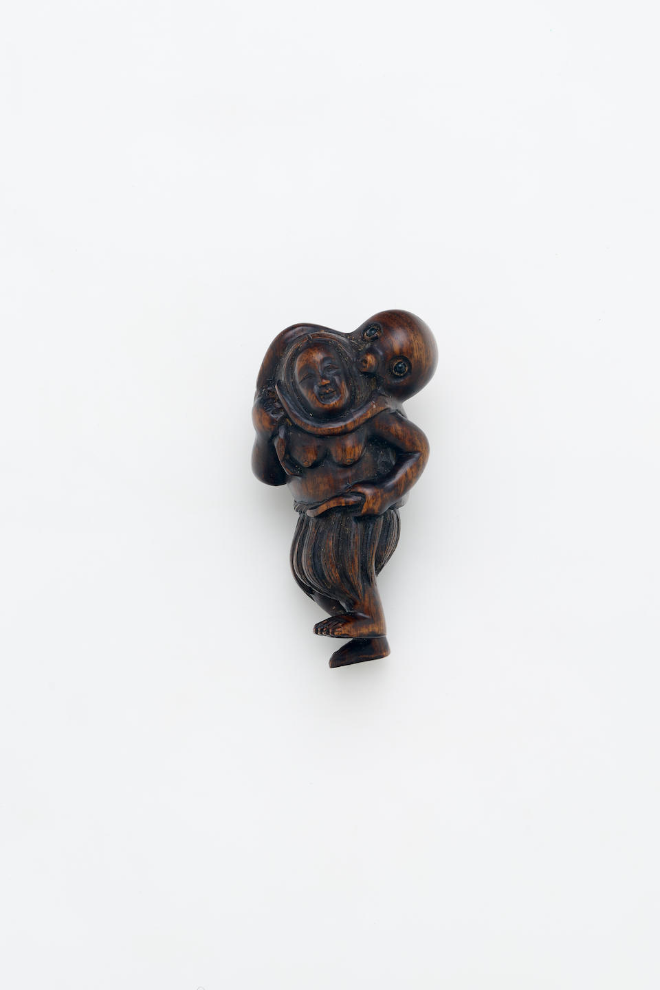 A WOOD NETSUKE OF A FISHER GIRL AND AN OCTOPUS, INLAID EYES Late 19th century