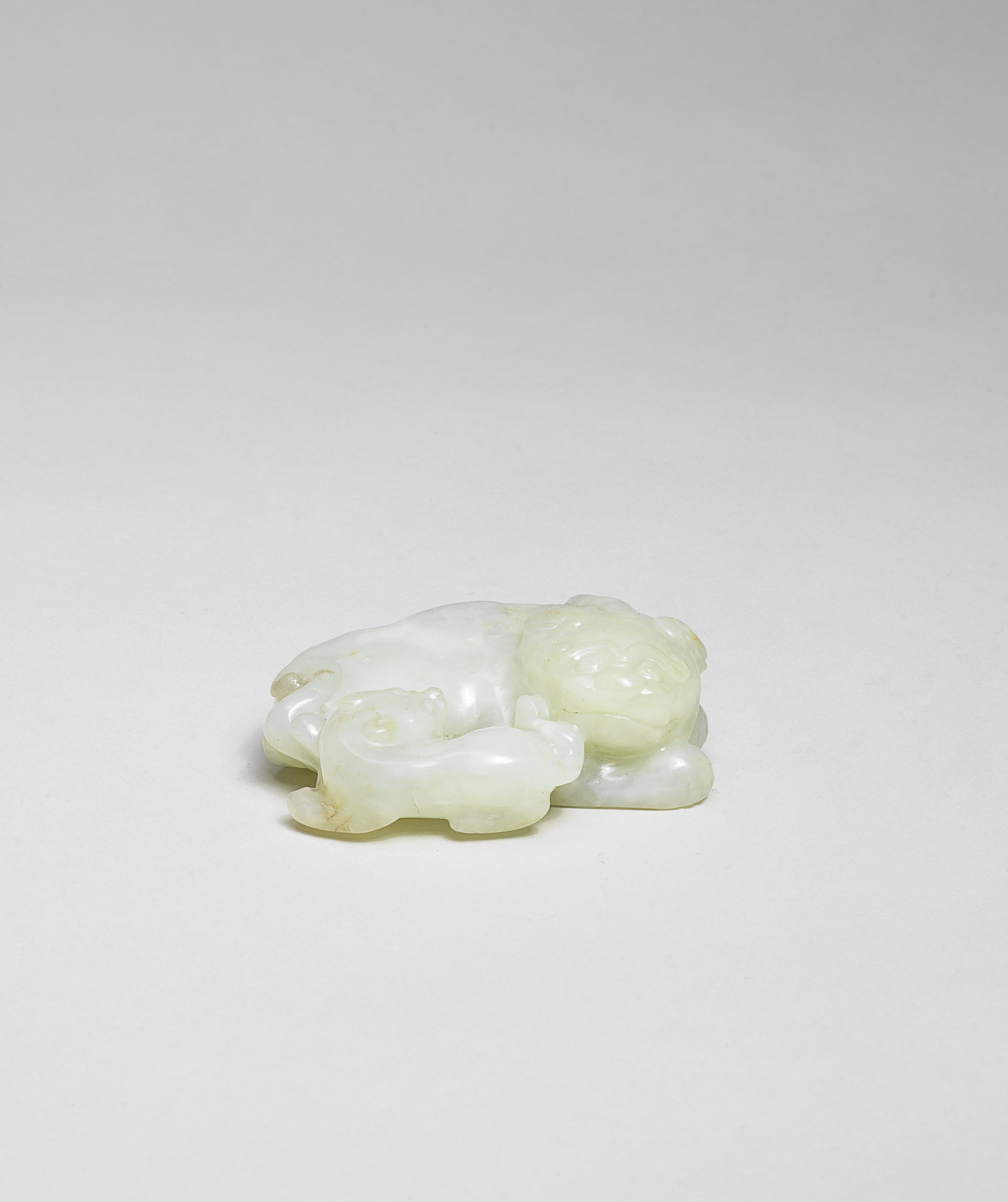 A PALE GREEN JADE CARVING OF A MYTHICAL BEAST AND CUB 17th/18th century