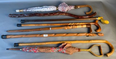 A collection of vintage walking sticks and umbrellas