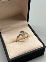 10ct yellow gold ring set with a pear drop cut yellow topaz stone flanked by white round cut