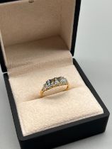 10ct yellow gold ring set with three oval cut blue stones and white round cut stones. [Ring size