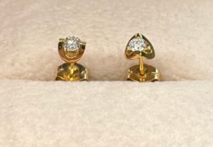 A Pair of 18ct yellow gold and round cut diamond stud earrings. 0.14cts- each diamond. [0.96grams]