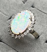 14ct white gold ladies ring set with an oval cut large opal stone surrounded by 0.64cts of diamonds.