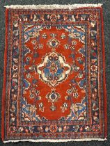 Antique hand made red ground Persian rug. [92x72cm]