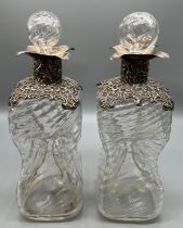 Two antique London silver and worked glass decanters. Ornate Silver trim to the rim and neck of