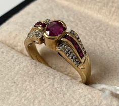 9ct yellow gold ring set with an oval cut ruby flanked by baguette cut rubies and round cut