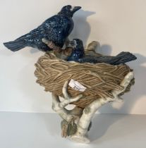 An antique Large porcelain bird nest sculpture, bird perched on a branch with bird cover insert