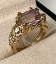 9ct yellow gold ring set with an emerald cut amethyst stone flanked by two round cut white sapphires