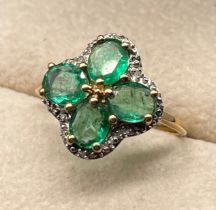 10ct yellow gold ring set with four oval cut emerald gem stones and four diamond chips. [Ring size