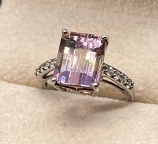 9ct white gold ring fitted with an emerald cut Amethyst stone off set by round cut white quartz