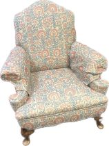 Victorian fireside chair, the whole covered in a blue and pink neutral upholstery, raised on short