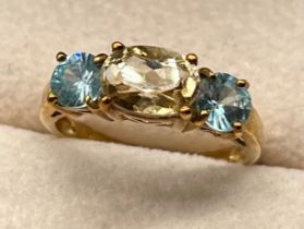 9ct yellow gold ring set with an oval cut citrine stone off set by single round cut blue topaz