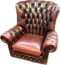 Chesterfield lounge chair, covered in a red leather button upholstery