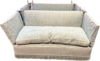 A pair of Knole settees, the whole covered in a green upholstery