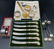 A Collection of silver items; Four silver napkin rings [83.35grams], Silver and horn porridge spoon,