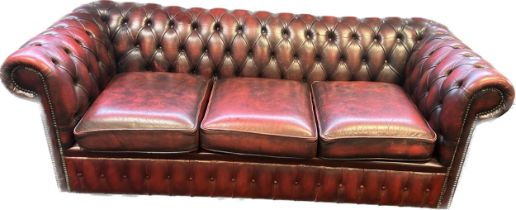 Chesterfield settee, covered in a red leather button upholstery