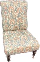 19th century nursing chair, the whole covered in a floral upholstery raised on turned legs ending in