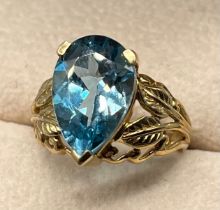 9ct yellow gold ornate leaf design ring set with a pear cut blue topaz stone. [Ring size N] [5.