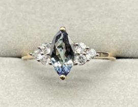 10ct yellow gold ring set with a diamond cut blue iolite gem stone off set with three white quartz