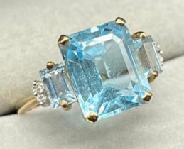 9ct yellow gold ring set with a cushion cut blue topaz, baguette cut blue topaz gem stones and two