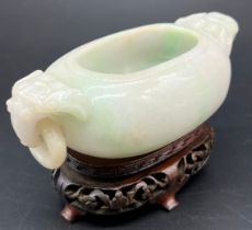 Antique Chinese pale jade small two handle urn vase, together with a later hand carved wooden stand.