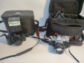 A cannon camera with lense & bag along with Olympus camera with bag