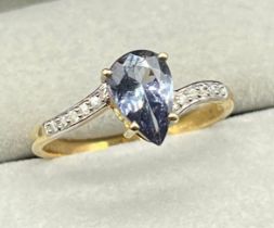 10ct yellow gold ring set with a pear drop cut blue Iolite gem stone off set by round cut white