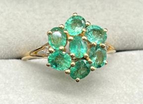 10ct yellow gold ring set with a cluster of seven oval cut emerald gem stones, with a single round