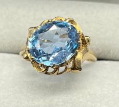 9ct yellow gold ring set with a large oval cut blue topaz stone. [Ring size O] [3.20Grams]