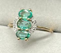 10ct yellow gold ring set with three oval cut emerald gem stones surrounded by diamonds. [Ring