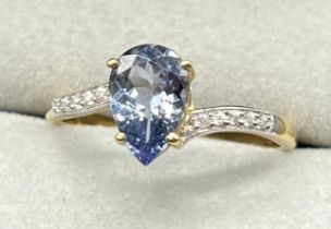 10ct yellow gold ring set with a pear cut blue iolite gem stone with round cut white spinel gem