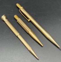Two 9ct gold revolving pencils together with a gold plated revolving pencil.