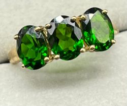 10ct yellow gold ring set with three oval cut green Tanzanite gem stones. [Ring size P] [2.82Grams]