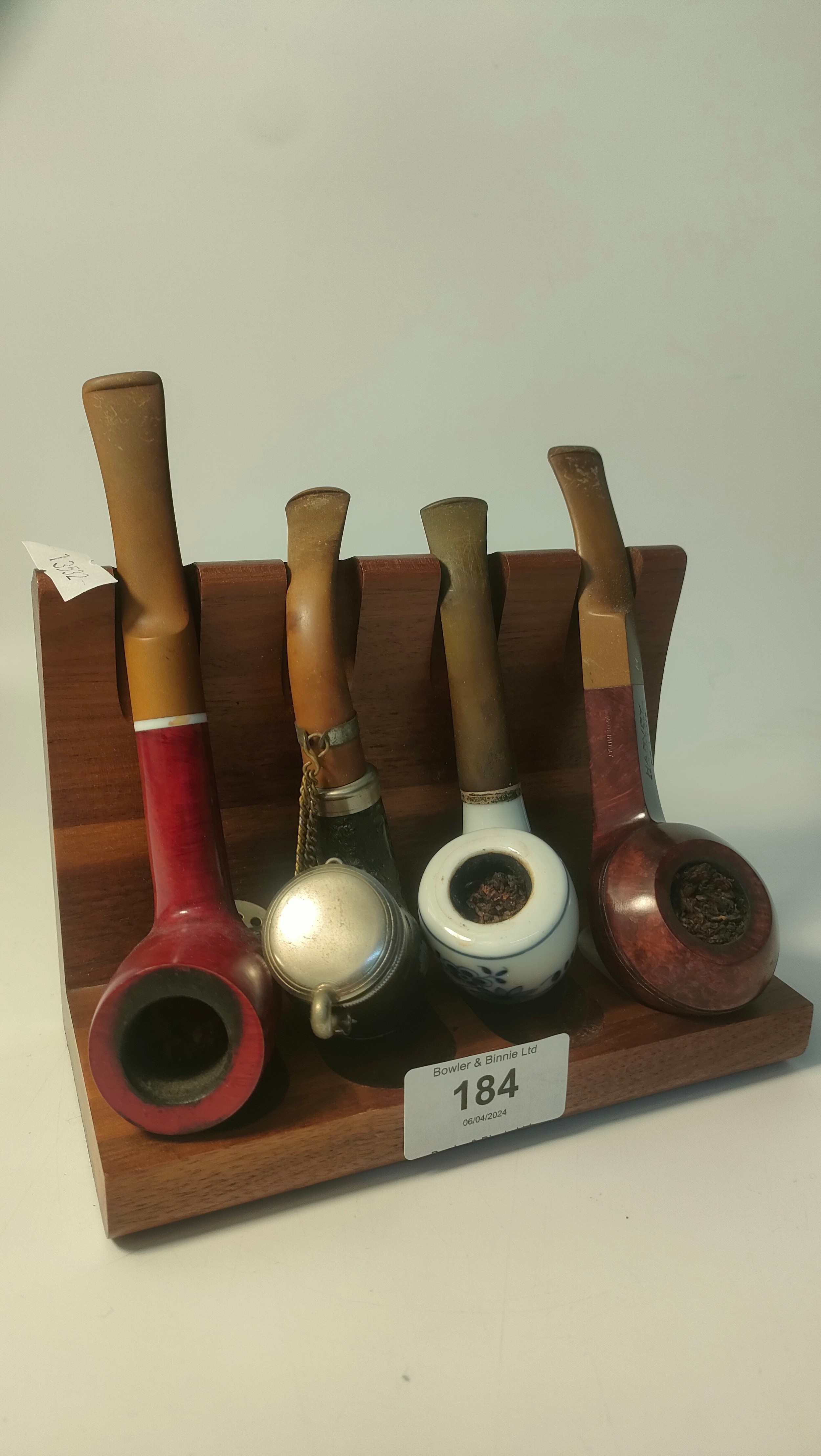 Four smoking pipes on display stand; Harvey pipe & swiss made pipe