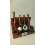 Four smoking pipes on display stand; Harvey pipe & swiss made pipe