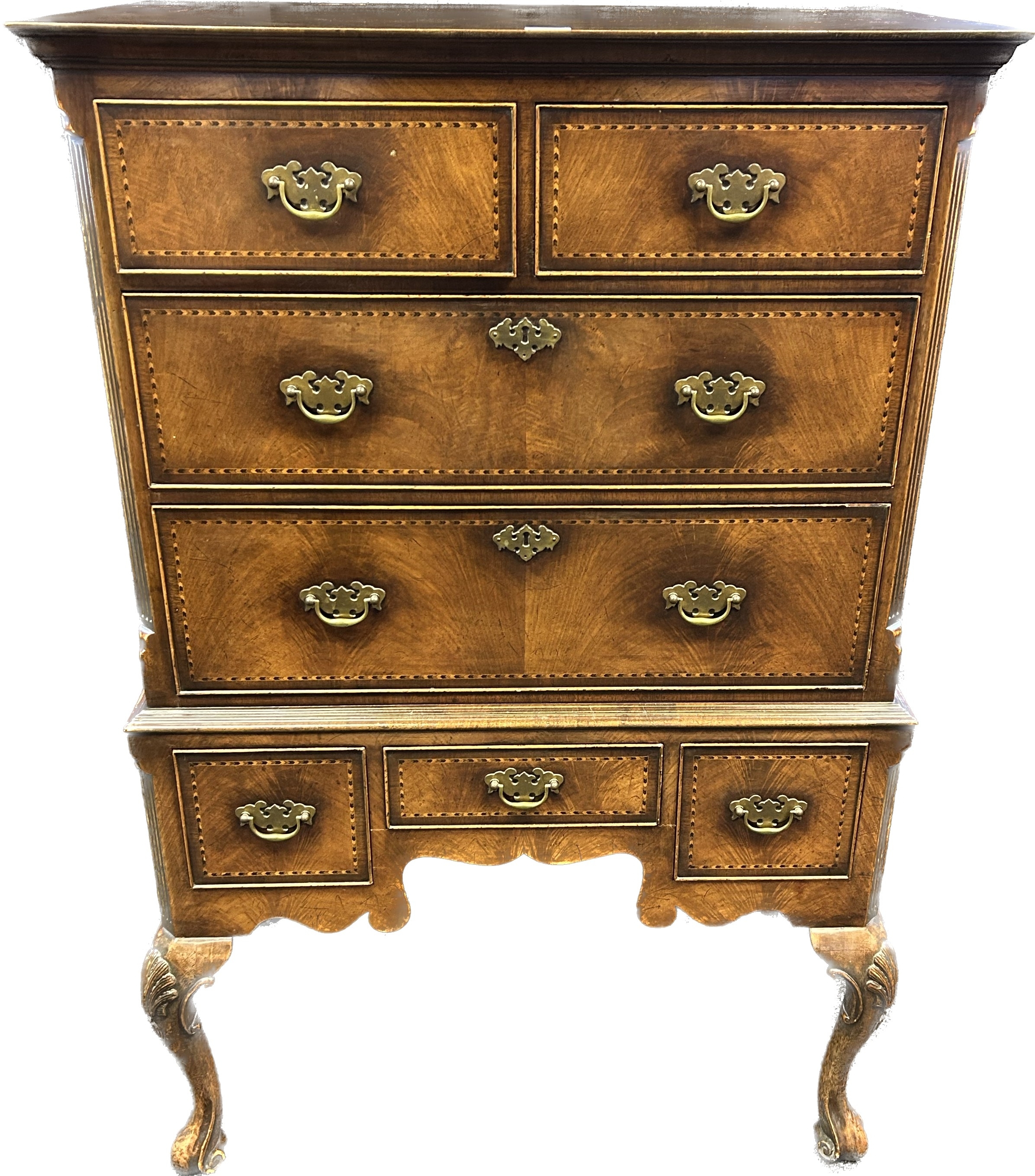 Reproduction walnut veneered chest on stand, the moulded cornice over an arrangement of drawers