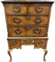 Reproduction walnut veneered chest on stand, the moulded cornice over an arrangement of drawers