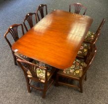 Antique mahogany extending table raised on two tripod bases ending in brass claw cap feet together