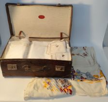 A collection of vintage linen in fitted brown case