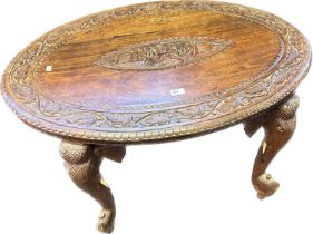Anglo Indian rosewood table with the oval surface with carved foliate design, the centre with