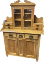 Pine farmhouse dresser, the top with glazed cupboard doors flanked by two short drawers, the base