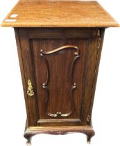 19th century mahogany bedside unit, the cupboard door with moulded carved design, raised on short